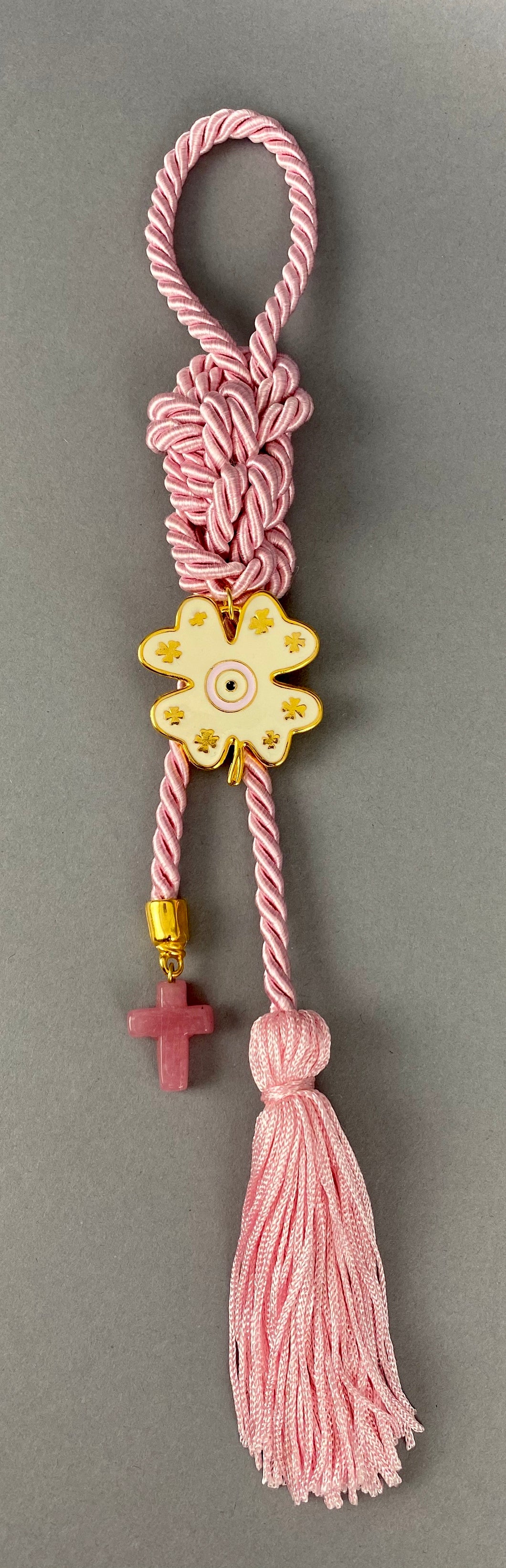 Gouri 1022 Pearl Pink  Cord Gouri, metal 4 leaf clover with Mati, glass cross with tassel.   Measures 13” in length.